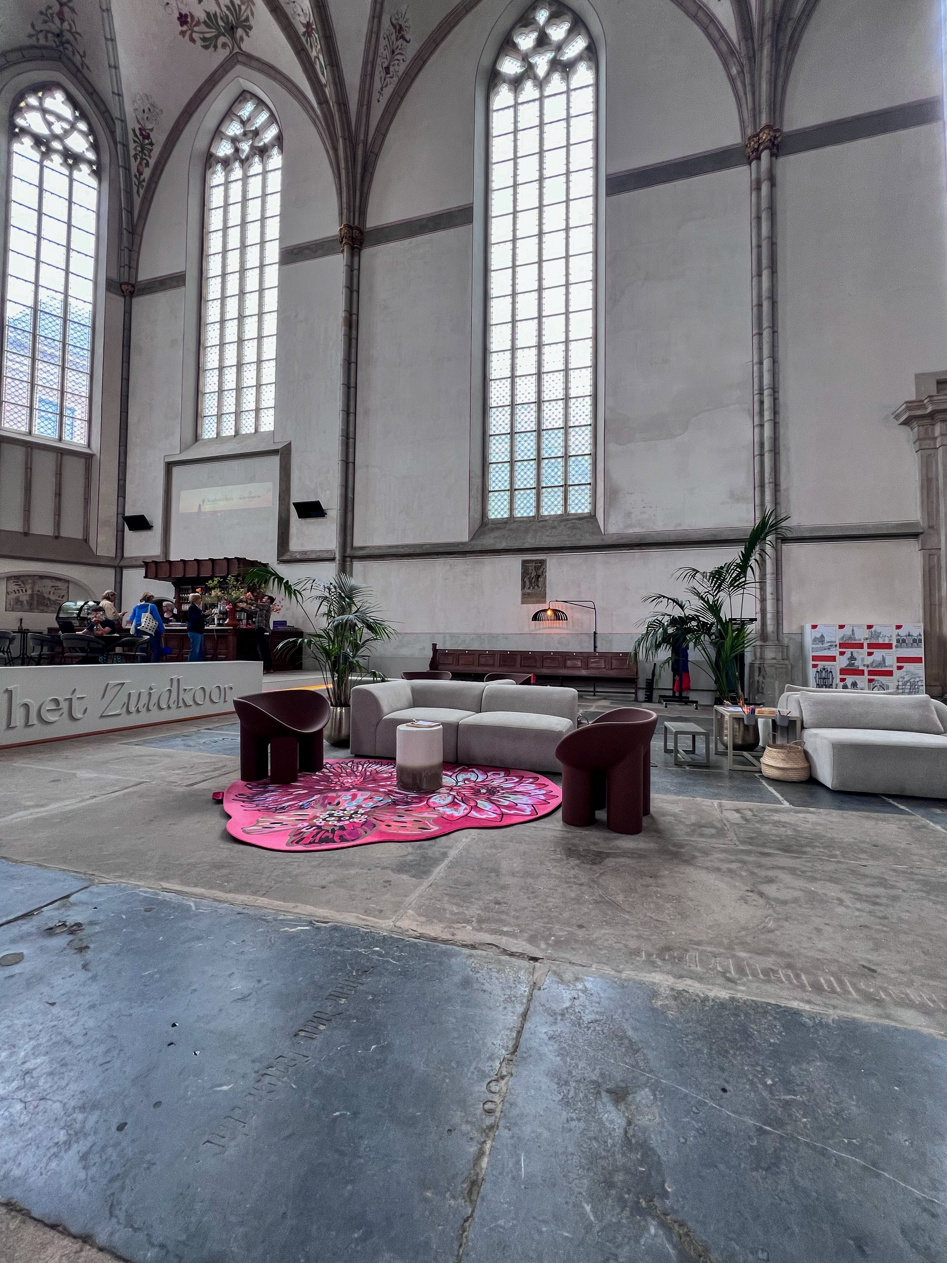 Luxe vloerkleed Dahlia Roze van Studio LilaLine met drie grote dahlia-bloemen in de hoofdrol – de bloemen zijn weelderig en gelaagd, opgebouwd uit rijke roze en rode tinten met hier en daar een warme oranje gloed. De vormen zijn rond en zacht, alsof de bloemblaadjes zich langzaam ontvouwen. Het kleed voelt zacht en warm aan, en straalt een romantische, uitnodigende sfeer uit in de ruimte.