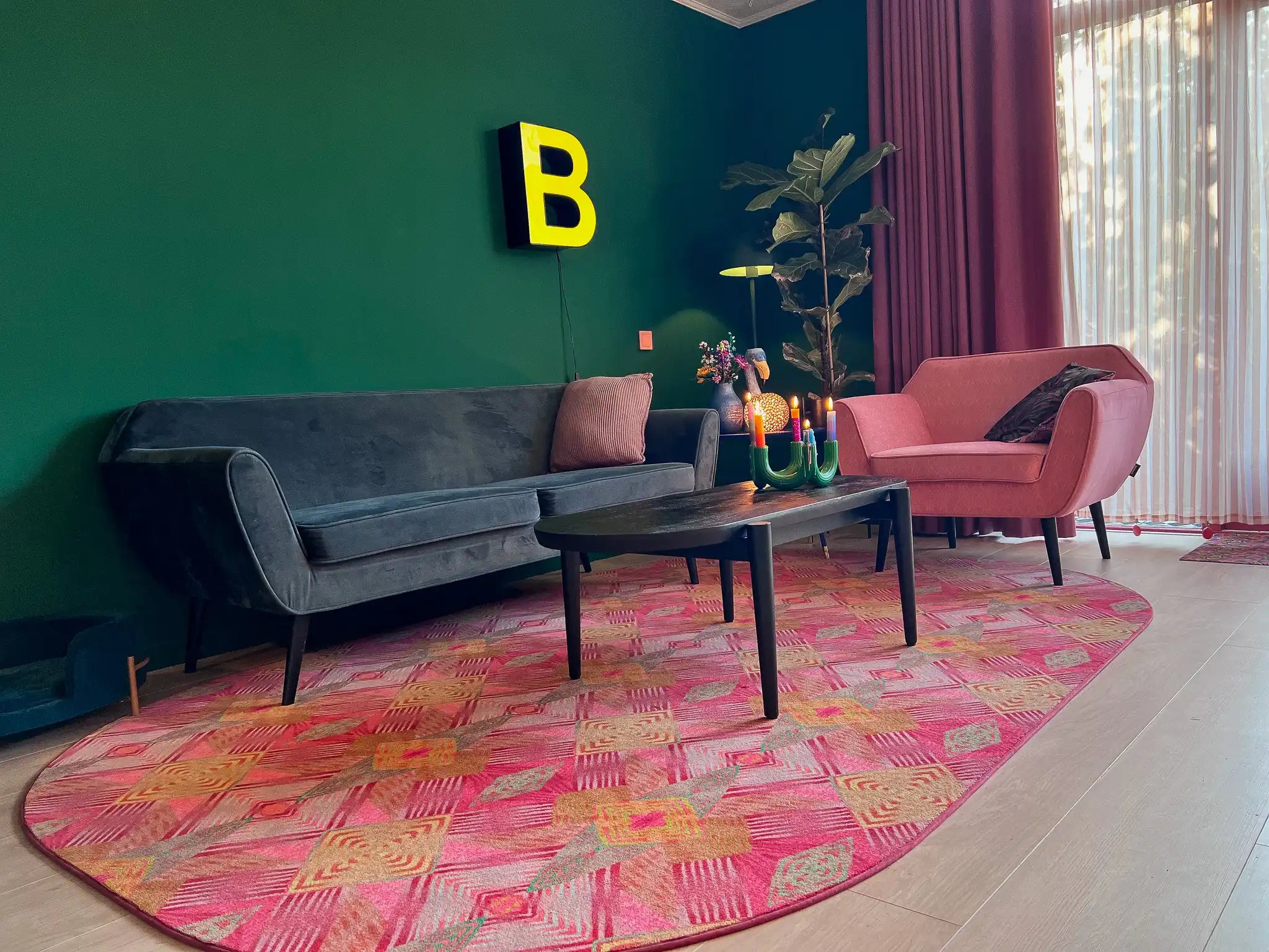 Luxe vloerkleed Diamond Pink van Studio LilaLine met een grafisch diamantpatroon in roze, groen en subtiele goudtinten – het kleed voelt zacht maar stevig aan, en het patroon bestaat uit ritmische vormen die in lagen over elkaar lijken te schuiven, alsof je naar een fonkelende caleidoscoop kijkt. De kleuren zijn warm, levendig en geven het kleed een rijke en speelse uitstraling.