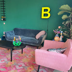 Luxe vloerkleed Diamond Pink van Studio LilaLine met een grafisch diamantpatroon in roze, groen en subtiele goudtinten – het kleed voelt zacht maar stevig aan, en het patroon bestaat uit ritmische vormen die in lagen over elkaar lijken te schuiven, alsof je naar een fonkelende caleidoscoop kijkt. De kleuren zijn warm, levendig en geven het kleed een rijke en speelse uitstraling.