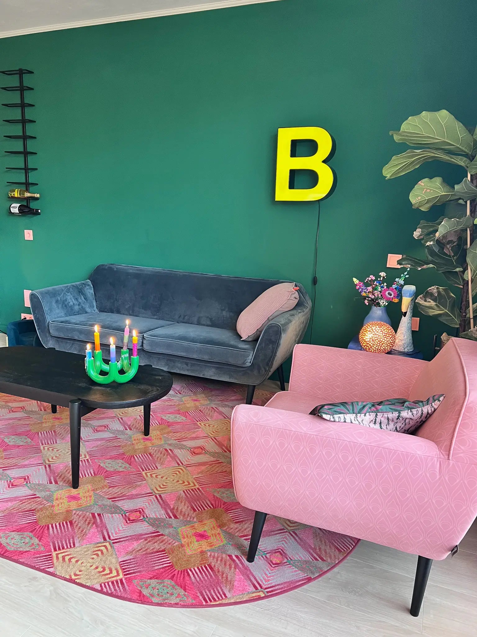 Luxe vloerkleed Diamond Pink van Studio LilaLine met een grafisch diamantpatroon in roze, groen en subtiele goudtinten – het kleed voelt zacht maar stevig aan, en het patroon bestaat uit ritmische vormen die in lagen over elkaar lijken te schuiven, alsof je naar een fonkelende caleidoscoop kijkt. De kleuren zijn warm, levendig en geven het kleed een rijke en speelse uitstraling.